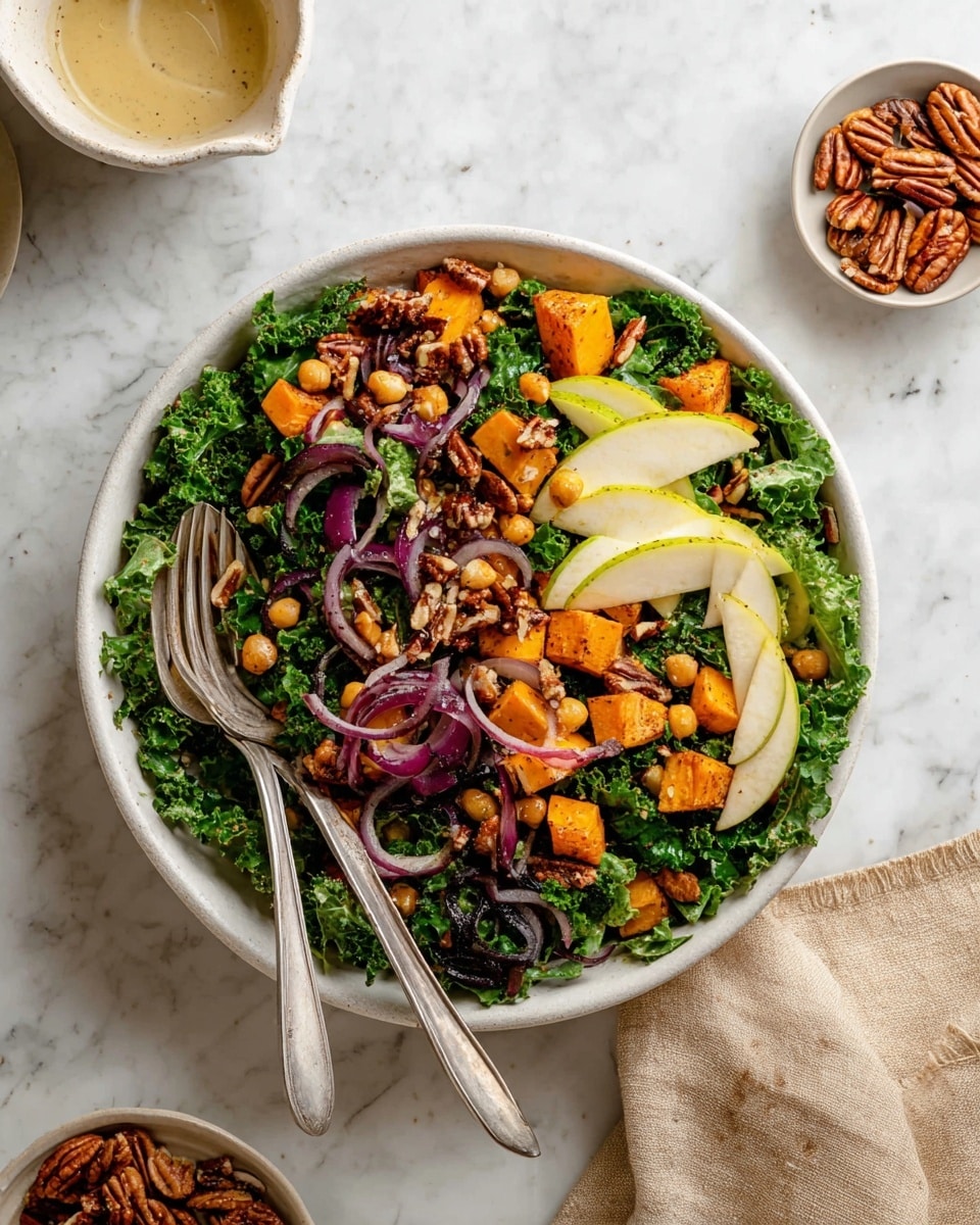 A white bowl filled with a colorful salad is placed on a white marbled surface. The salad has three main visible layers: the bottom layer is bright green kale leaves with a rough texture, the middle layer contains thin slices of light yellow apple and deep purple red onion rings, and on top are small chunks of orange roasted sweet potato, light brown chickpeas, and golden brown pecans, with some whole grain mustard seeds scattered throughout. Two silver forks rest on the left side of the bowl, one holding a small portion of kale. Nearby are a small white bowl with pecans and a white container with dressing. A beige cloth is partially visible at the bottom right. photo taken with an iphone --ar 4:5 --v 7