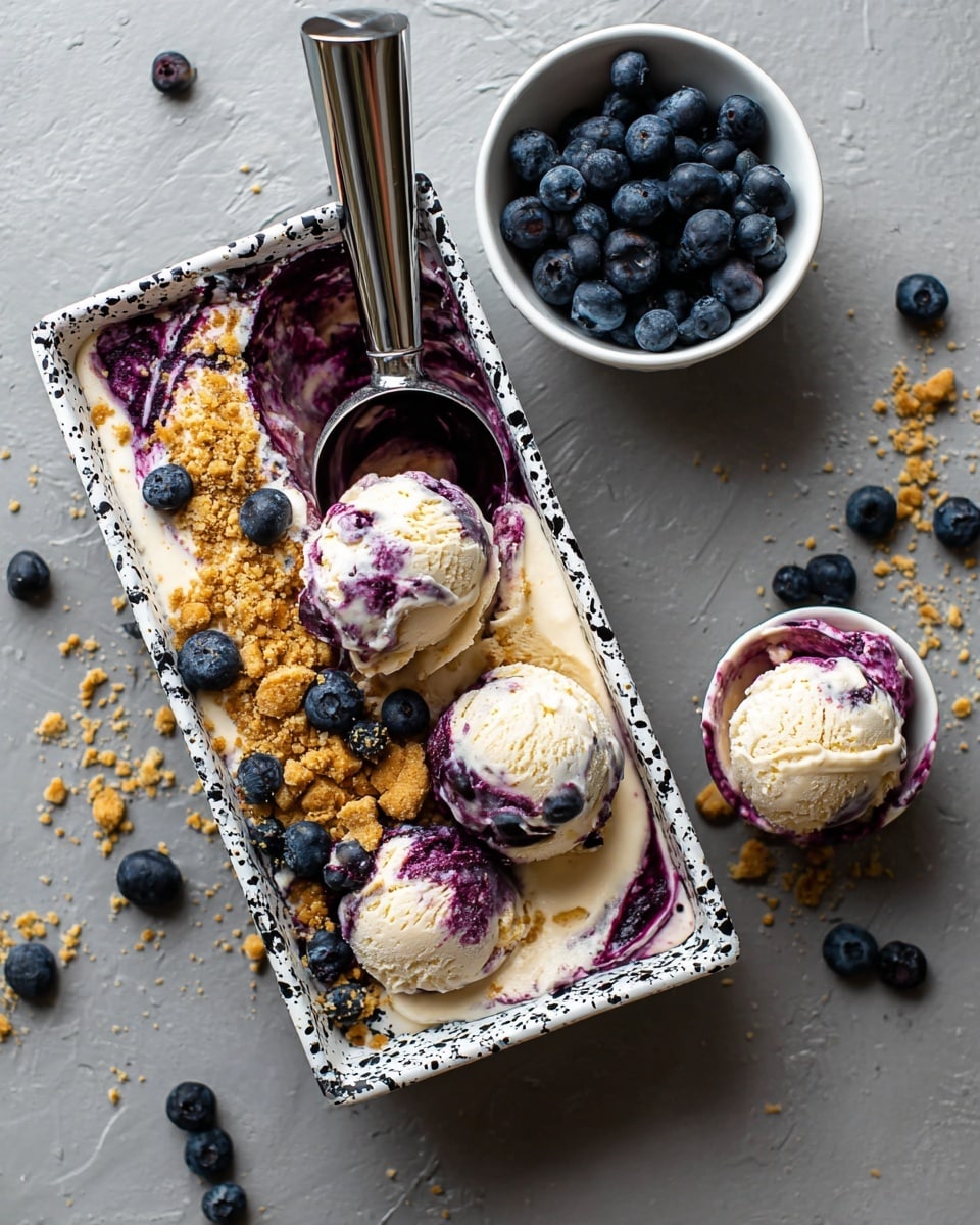 A rectangular white tray with black splatter pattern holds a mixed dessert with two main layers: a creamy off-white layer mostly melted and a swirl of deep purple blueberry layer on the side covered partially with a crumbly golden brown topping. Four scoops of the creamy purple-streaked ice cream sit on top, with a shiny silver scoop resting inside the tray, partially filled. Nearby, a small white bowl filled with fresh blueberries and a white round bowl holding two scoops of the dessert with the bowl turned upside down next to it are placed on a white marbled surface scattered with some loose blueberries. photo taken with an iphone --ar 4:5 --v 7