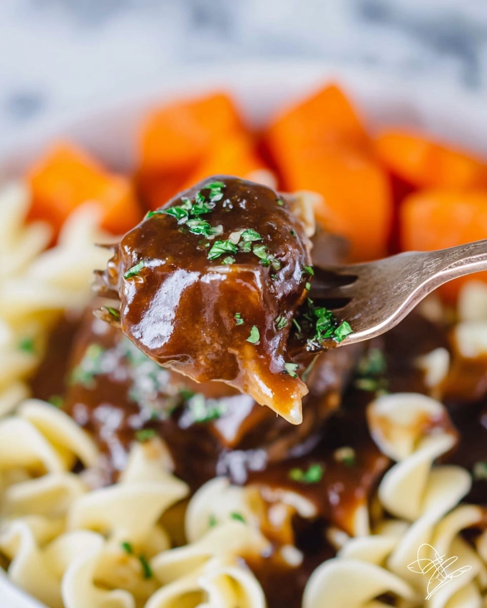 A close-up of a fork holding a bite of layered food: the top layer is a glossy dark brown sauce with small green herb bits on it, covering a piece of tender meat, under which is a light beige, curly egg noodle that looks soft and slightly saucy. In the blurred background, there are bright orange chunks of carrot layered behind the noodles and sauce, all served on a white plate sitting on a white marbled surface. The overall look is rich, warm, and comforting with a mix of smooth sauce, tender meat, and textured noodles. Photo taken with an iphone --ar 4:5 --v 7