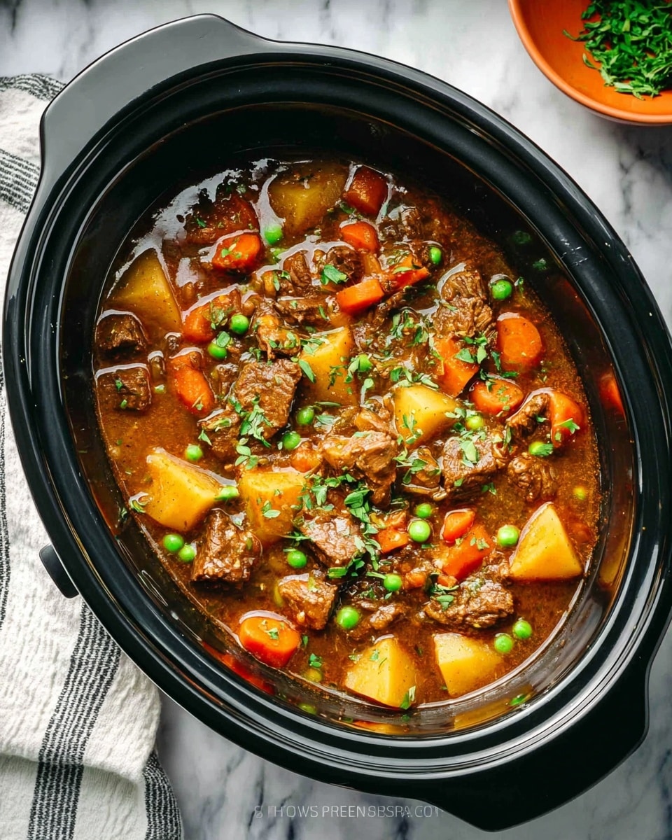 A close-up view inside a black slow cooker shows a hearty stew with three main layers: at the bottom, there is a rich brown broth; in the middle, there are chunky pieces of cooked beef, orange carrot slices, light yellow potato cubes, and bright green peas, all mixed together; scattered on top is a sprinkle of fresh green herbs adding a touch of color. The slow cooker sits on a white marbled textured surface, with a white and gray striped cloth partially visible on the left side, and a small orange bowl with green herbs slightly out of focus in the background. Photo taken with an iphone --ar 4:5 --v 7