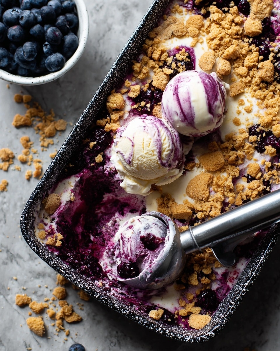 The image shows a close-up of a black and white speckled rectangular dish filled with a layered dessert. The bottom layer is a deep purple berry mix with a chunky texture. Above it, there is a creamy white ice cream melted and mixed with the berries. On top, golden brown crumbled pieces are scattered unevenly, adding a crunchy texture. Two scoops of ice cream scoop are placed on the dessert, both swirled with purple berry syrup. A silver ice cream scooper with some dessert stuck to it hovers over the dish. In the corner, there is a small white bowl with fresh blueberries on a white marbled surface. photo taken with an iphone --ar 4:5 --v 7